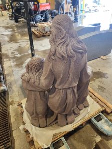 Rear view of granite sculpture of mother and children
