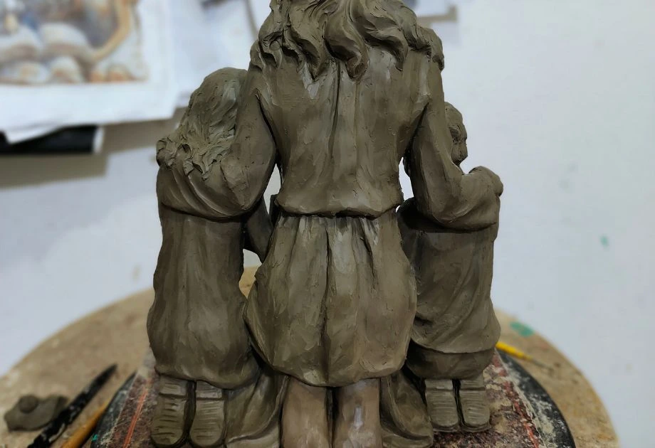 Clay sculpture of mother and children front - back