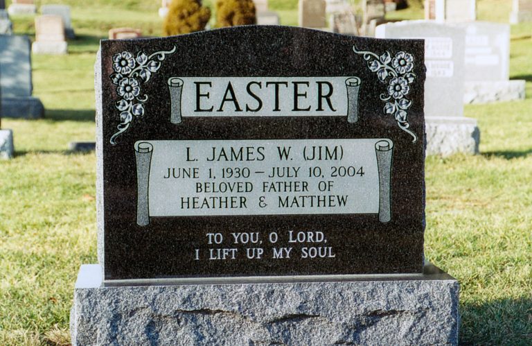 A black granite memorial with flowers