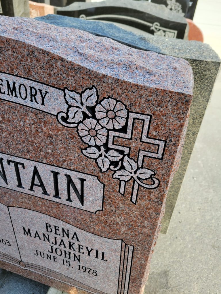 Flat carved flowers on a granite memorial