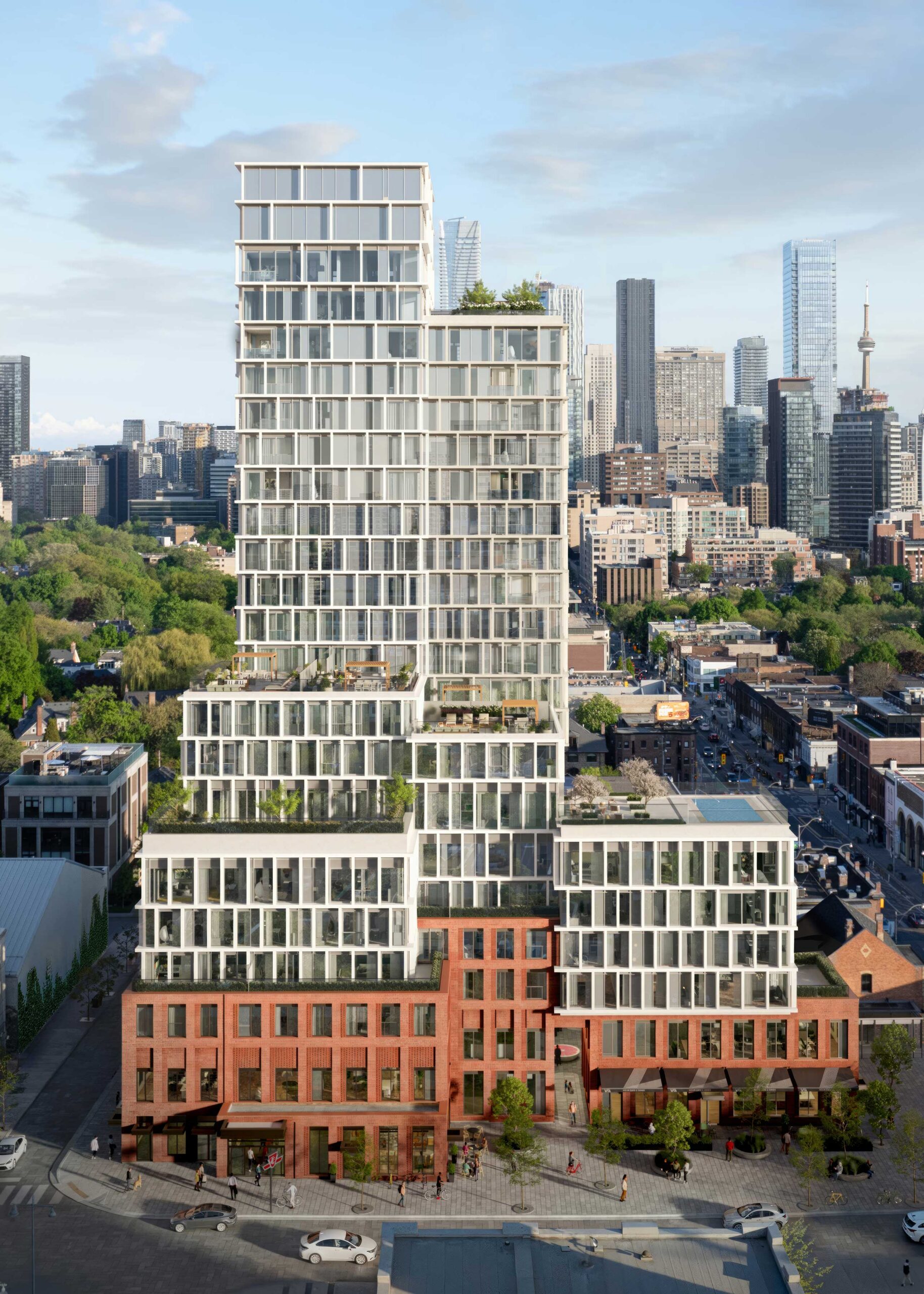 A contemporary mixed-use high-rise rises above a city neighborhood.